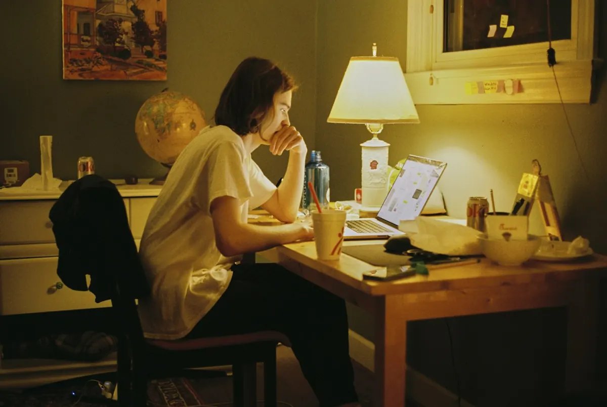Mulher estudando à noite em casa, sob a luz de um abajur